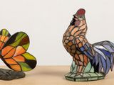 two figurines of a rooster and a butterfly on a table