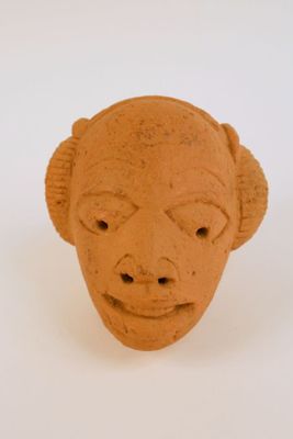 une sculpture en argile représentant le visage d'un homme sur une surface blanche