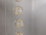 a glass display case with five different coins in it