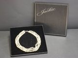 a close up of a necklace and a box on a table