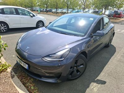a grey car parked in a parking lot next to other cars