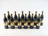 twelve bottles of wine lined up in a row on a white surface