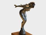 statue d'une femme posée sur un socle en bois, tenant une raquette de tennis