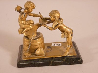 brass figurine of two cherensils on a marble base