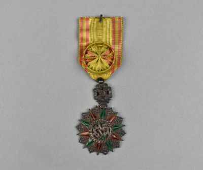 une médaille d'or entourée d'un ruban rouge et jaune