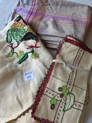 several pieces of cloth with embroidered designs on them sitting on a bed