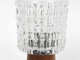 a close up of a glass lamp on a wooden base