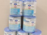 six tins of intex water sitting on top of a table