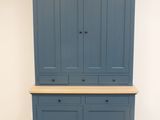 une grande armoire bleue avec deux tiroirs et un plateau en bois