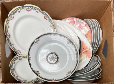 a cardboard box filled with plates and bowls in it