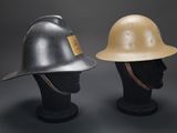 two helmets on a mannequin head on a black background