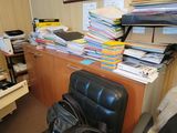 a black chair in front of a desk with a backpack on it