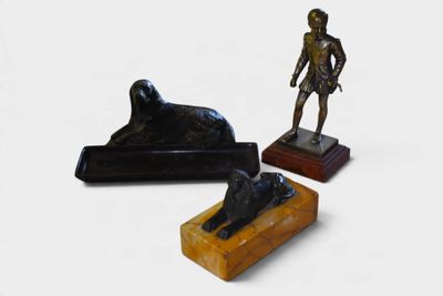une statue représentant un homme debout à côté d'une statue représentant un chien