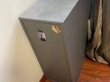 an image of a small metal cabinet in the corner of a room