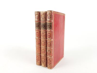 two old books sitting on top of each other on a white surface