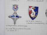 three pins on a piece of paper with a drawing of a cross