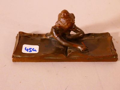 figurine en bronze représentant une femme assise sur un livre