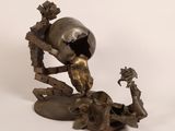 bronze sculpture of a skull and a bird on a table