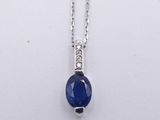 a blue sapphire and diamond pendant on a silver chain