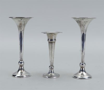 trois bougeoirs en argent sont posés les uns à côté des autres sur une table