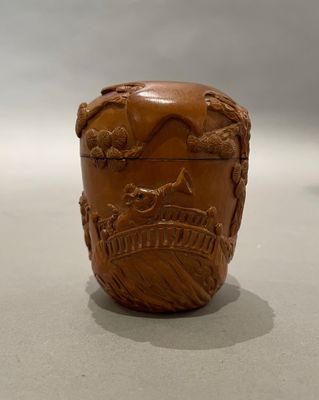 un vase marron orné d'un cheval, posé sur une table