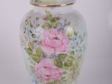 un vase blanc orné de fleurs roses et bleues
