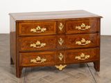 a wooden chest of drawers with gold decorations on it
