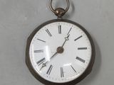 a silver pocket watch with roman numerals on the face