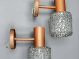 deux appliques en cuivre et en verre fixées à un mur gris