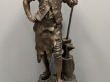 bronze statue of a boy with a bag and a stick