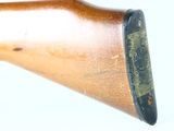 an old wooden rifle with a wooden barrel and a black handle