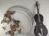a violin and a butterfly sculpture on a shelf