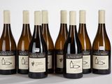 six bouteilles de vin sont alignées sur une surface blanche