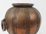 a small copper vase with a handle on a white background