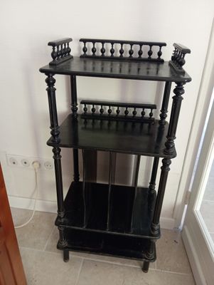 une étagère noire qui se trouve dans un coin de la pièce