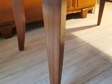 a wooden table with two legs on a wooden floor
