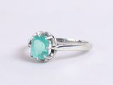 a close up of a ring with a green stone in it