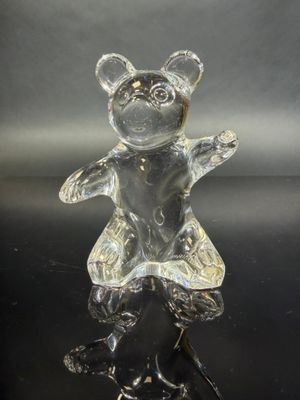 crystal figurine of a teddy bear in a dress on a black surface