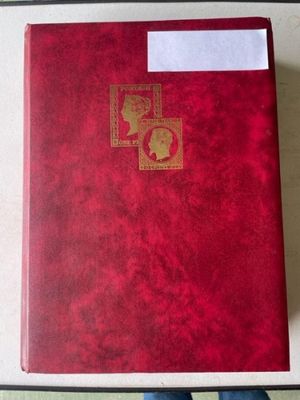 quelqu'un tient un livre rouge orné d'un cachet doré