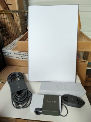 une boîte blanche posée sur une table, à côté d'un chargeur