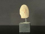 sculpture of a head on a block on a black surface
