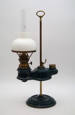 une lampe à huile à l'ancienne, surmontée d'un abat-jour en verre