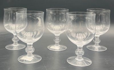 six empty wine glasses sitting on a table with a dark background