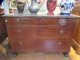 une commode en bois avec un plateau en marbre sur lequel est posé un vase