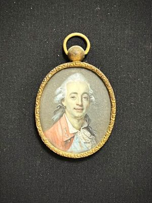 Une vieille photo représentant un homme vêtu d'un manteau rouge est exposée dans un cadre doré.