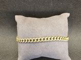 un bracelet en chaîne d'or posé sur un oreiller