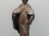 une vieille statue en bronze représentant une femme tenant un sac