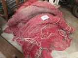 a pile of red netting on the ground next to a pile of motorcycles