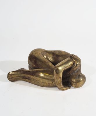 a bronze sculpture of a dog laying down on its back