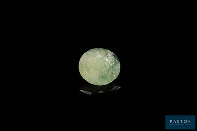 une image représentant une boule de jade verte posée sur une surface noire